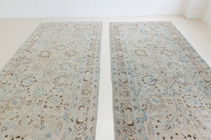 This pair of vintage handknotted Persian rugs are from the Tabriz region. Perisa is one of the oldest rug weaving centres in the world featuring floral patterns and muted colours as seen on these carpets.