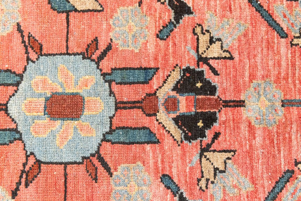 Lilian rugs were handwoven in a small village in Western Iran and often feature floral and geometric patterns as seen here. This small vintage carpet features a soft pink and blue colour palette and an intricate design inspired by nature.