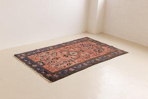 Lilian rugs were handwoven in a small village in Western Iran and often feature floral and geometric patterns as seen here. This small vintage carpet features a soft pink and blue colour palette and an intricate design inspired by nature.