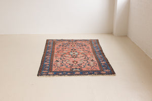 Lilian rugs were handwoven in a small village in Western Iran and often feature floral and geometric patterns as seen here. This small vintage carpet features a soft pink and blue colour palette and an intricate design inspired by nature.