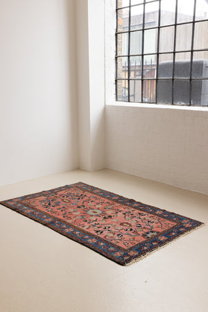 Lilian rugs were handwoven in a small village in Western Iran and often feature floral and geometric patterns as seen here. This small vintage carpet features a soft pink and blue colour palette and an intricate design inspired by nature.