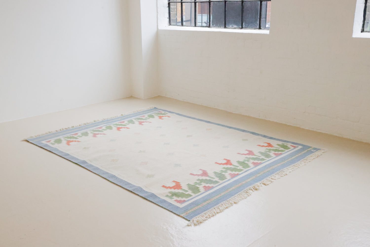 This is an original Swedish röllakan rug handwoven by the mid-century textile designer Anna Johanna Angström. This colourful vintage kilim rug often feature strong lines and designs inspired by floral and botanical motifs.