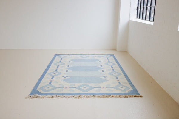 This beautiful vintage Swedish flatweave rug features a stunning blue colour palette and an elegant geometric design.