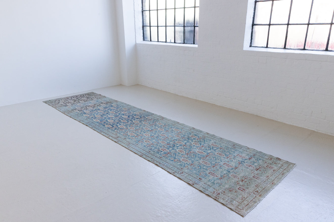 Isabelle is a Persian Malayer runner with a beautiful palette of blues and terracotta softened by a wonderful patina. The antique runner also features the iconic Boteh motif symbolising growth and resilience. 