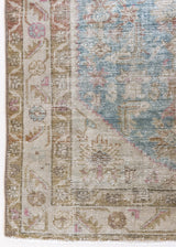 Olive is a Mahal Persian carpet featuring a large central medallion in soft blue and a wide floral boarder with vine scrollwork.