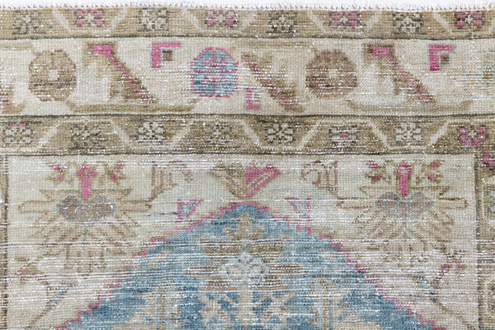 Olive is a Mahal Persian carpet featuring a large central medallion in soft blue and a wide floral boarder with vine scrollwork.