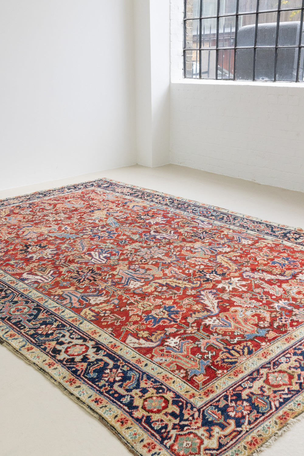 This is a handmade antique Heriz rug woven in Persia. The Heriz region is known for producing some of the most ornate Persian carpet, often known for their mesmerising and intricate repeating patterns.
