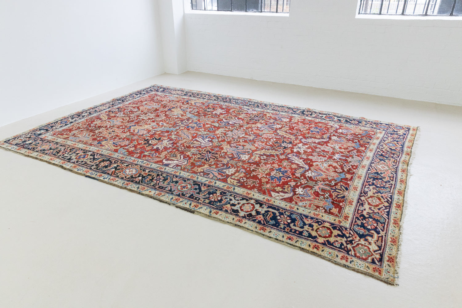 This is a handmade antique Heriz rug woven in Persia. The Heriz region is known for producing some of the most ornate Persian carpet, often known for their mesmerising and intricate repeating patterns.