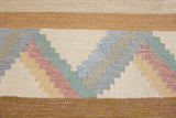 A Swedish geometric-patterned rug with multicolor border on a beige background. This röllakan rug was handwoven by the mid-century textile designer Anna Johanna Angström.