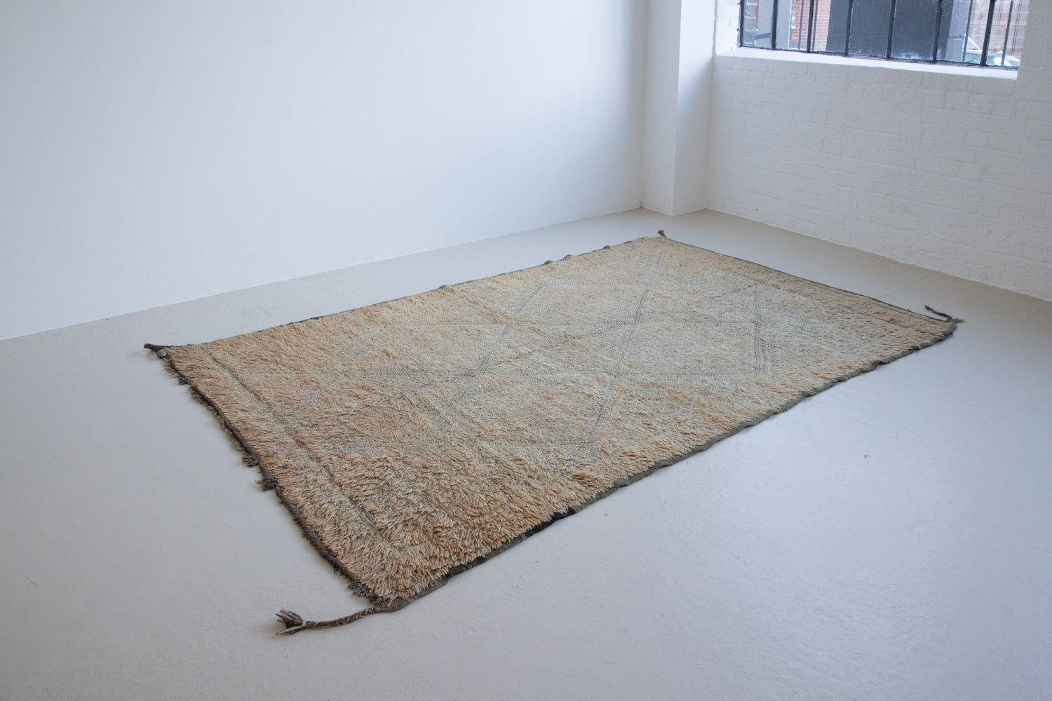 Textured thick pile antique Moroccan rug with a geometric pattern on a peach background