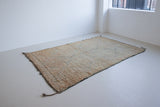 Textured thick pile antique Moroccan rug with a geometric pattern on a peach background
