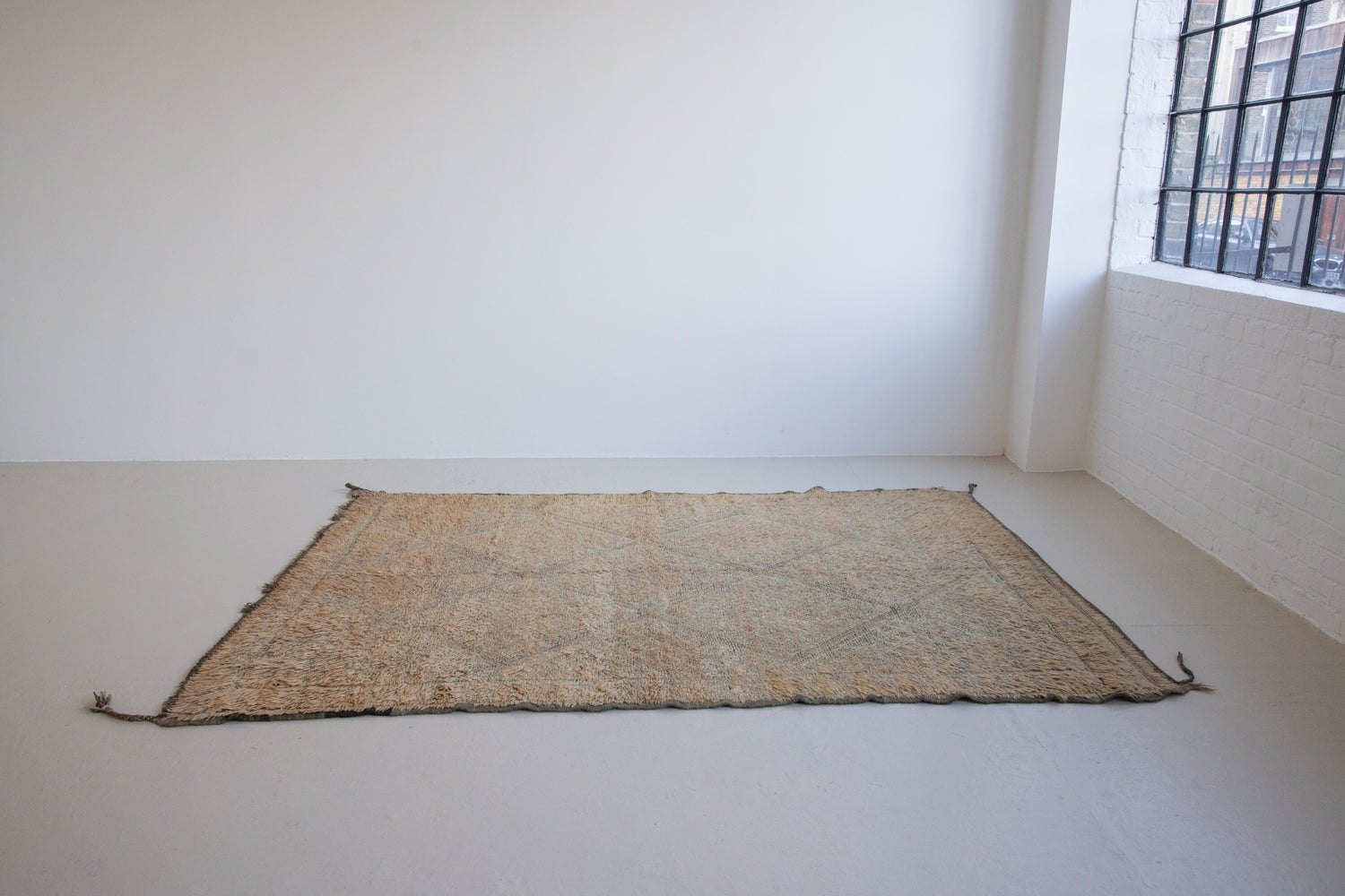 Textured thick pile antique Moroccan rug with a geometric pattern on a peach background