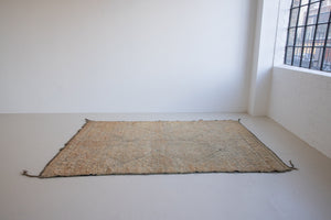 Textured thick pile antique Moroccan rug with a geometric pattern on a peach background