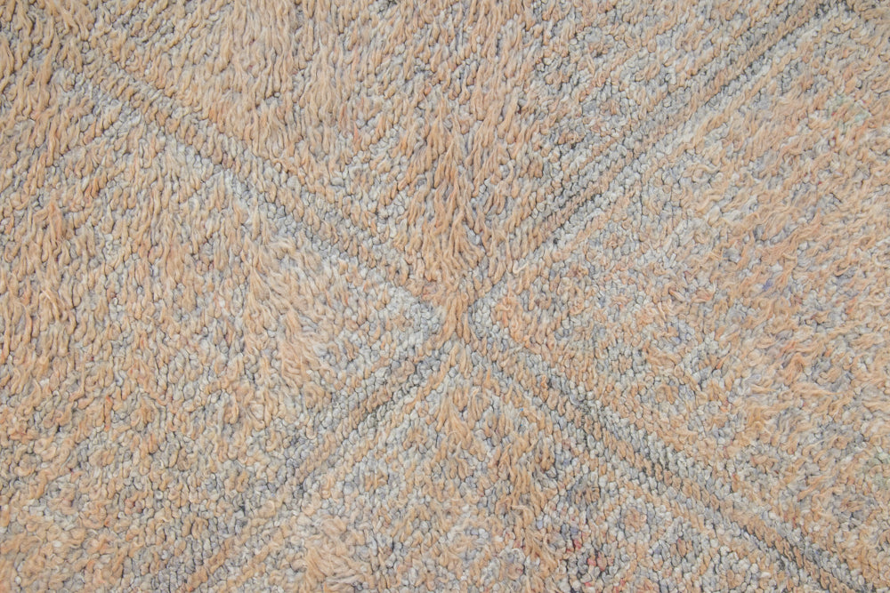 Textured thick pile antique Moroccan rug with a geometric pattern on a peach background