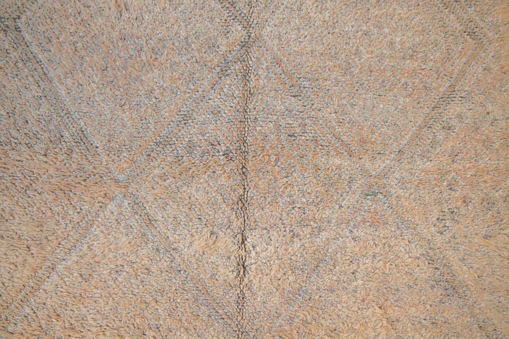 Textured thick pile antique Moroccan rug with a geometric pattern on a peach background