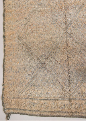 Textured thick pile antique Moroccan rug with a geometric pattern on a peach background