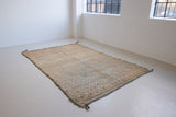 Textured thick pile antique Moroccan rug with a geometric pattern on a peach background