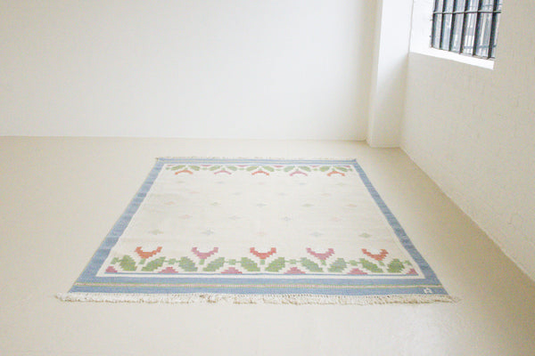 This is an original Swedish röllakan rug handwoven by the mid-century textile designer Anna Johanna Angström. Her colourful kilims often feature strong lines and designs inspired by floral and botanical motifs