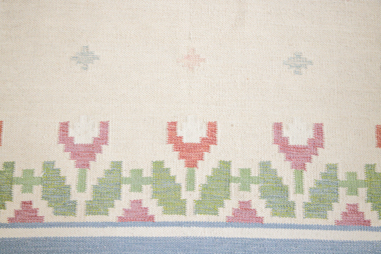This is an original Swedish röllakan rug handwoven by the mid-century textile designer Anna Johanna Angström. Her colourful kilims often feature strong lines and designs inspired by floral and botanical motifs