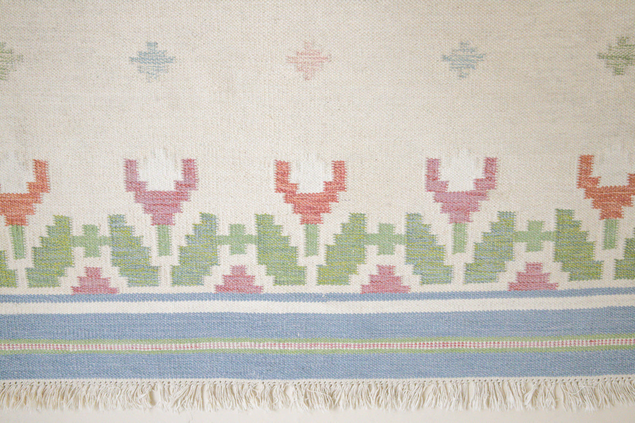 This is an original Swedish röllakan rug handwoven by the mid-century textile designer Anna Johanna Angström. Her colourful kilims often feature strong lines and designs inspired by floral and botanical motifs
