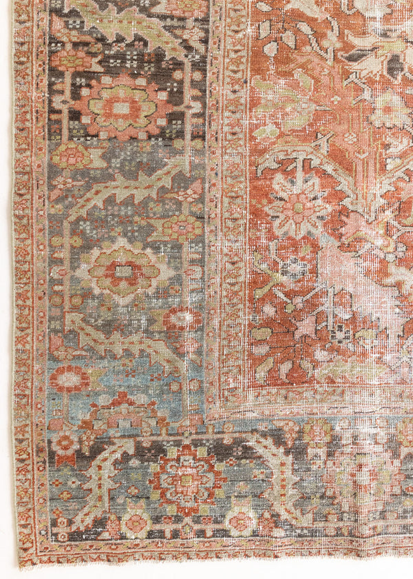 A Heriz carpet. The Heriz is one of the most sought after and recognisable Persian designs, known for vibrant colours and bold geometric patterns. The Penelope rug features an intricate, ubiquitous all-over floral and palmette motifs with a muted rust ground and blue toned boarder.