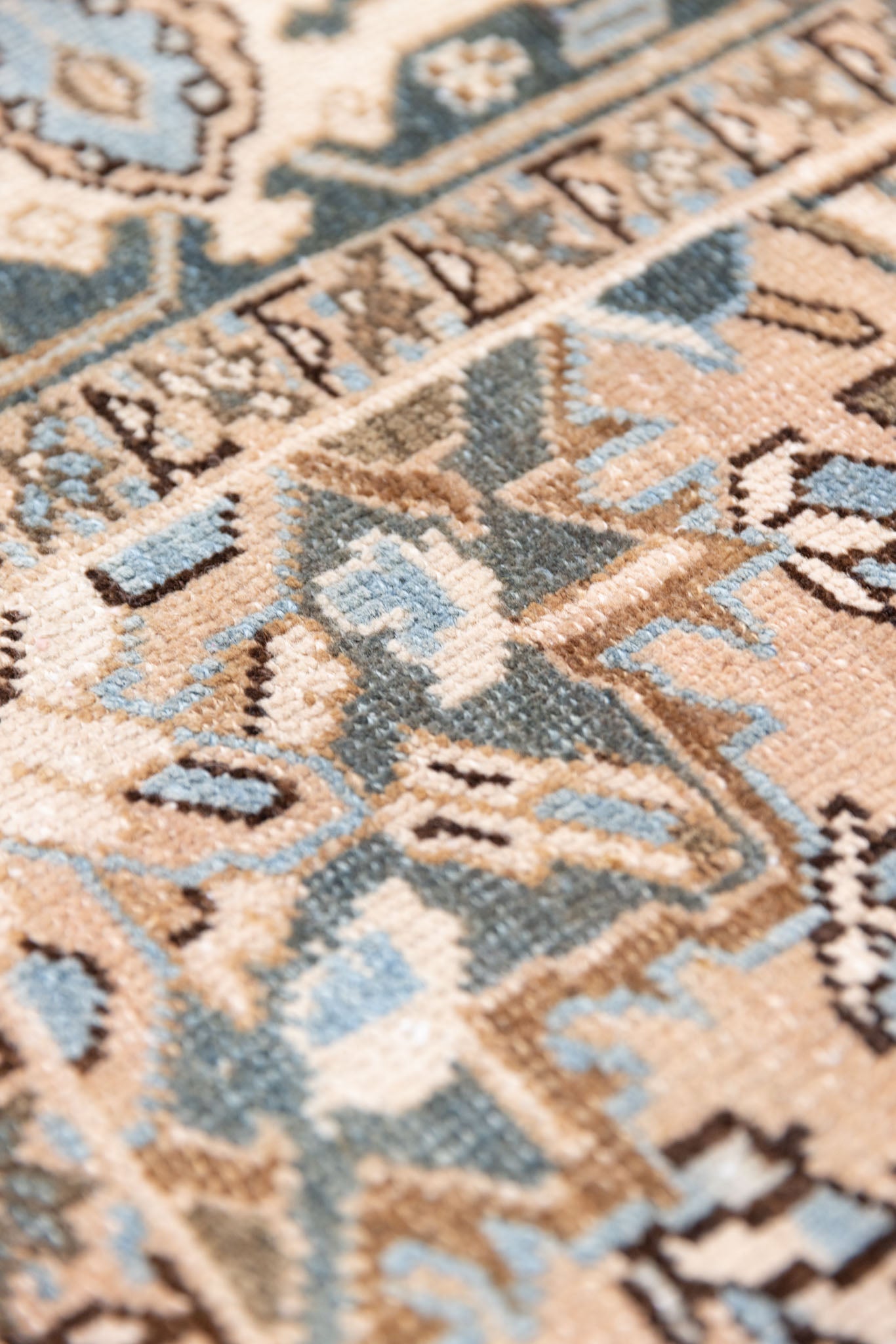 This is a vintage Persian Heriz rug. With a unique antique wash, this carpet boasts a muted palette in soft blue with flashes of red and brown