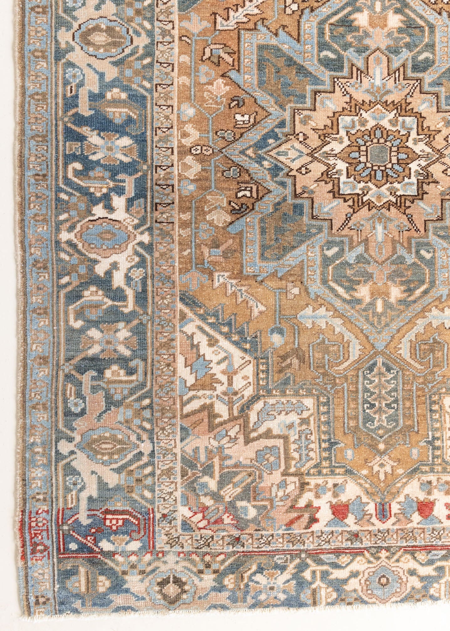 This is a vintage Persian Heriz rug. With a unique antique wash, this carpet boasts a muted palette in soft blue with flashes of red and brown