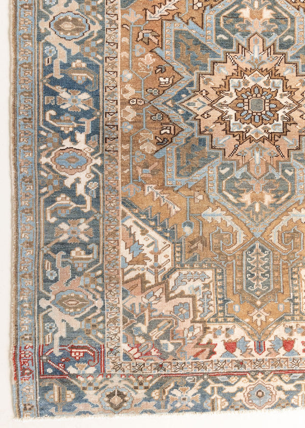 This is a vintage Persian Heriz rug. With a unique antique wash, this carpet boasts a muted palette in soft blue with flashes of red and brown