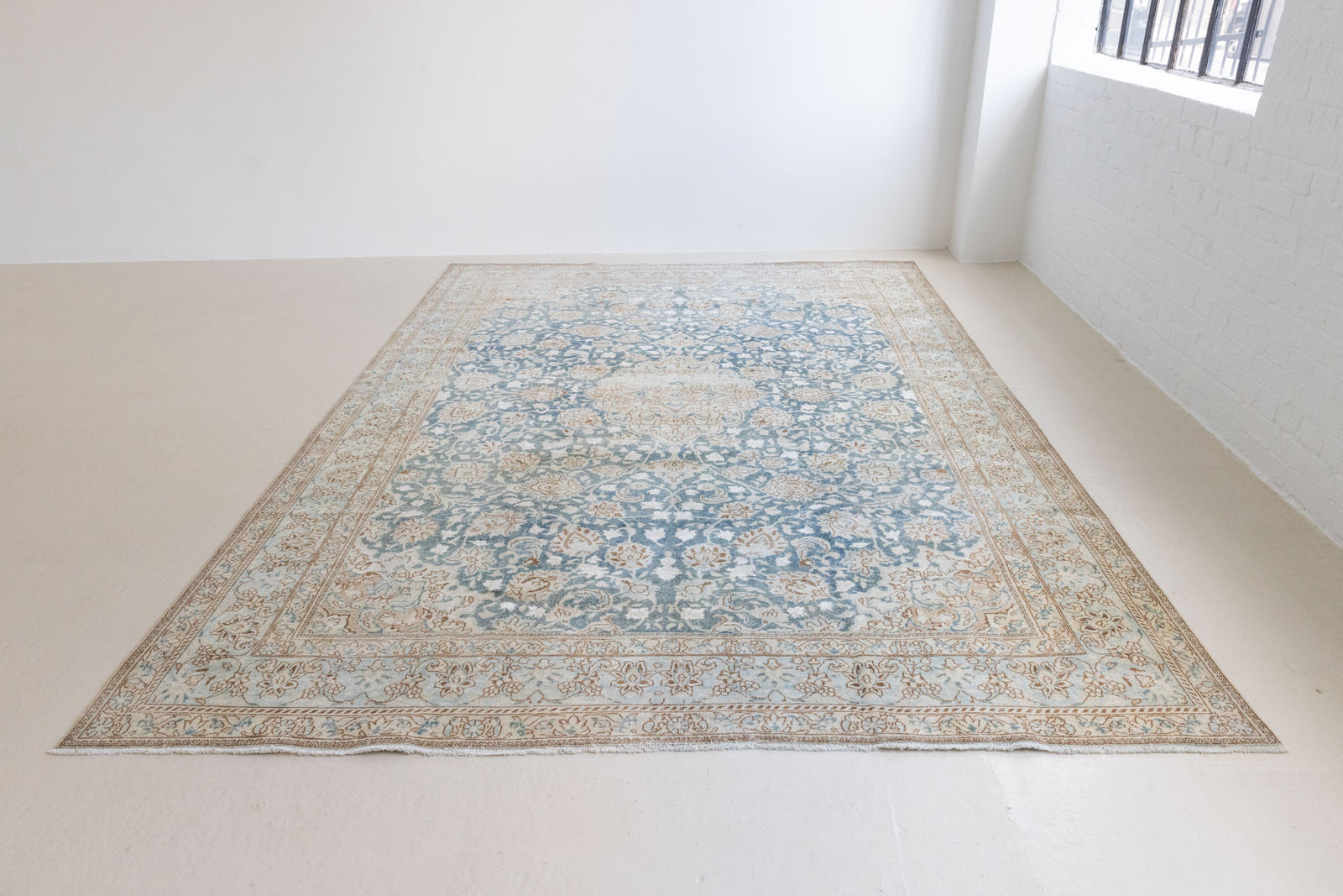 This is a vintage Persian Keshan rug that has been over-dyed to gently fade its original colours, giving a more neutral palette. Persia has the most desirable rugs and carpets with stunning designs such as this carpet. Now available at Ourika London.