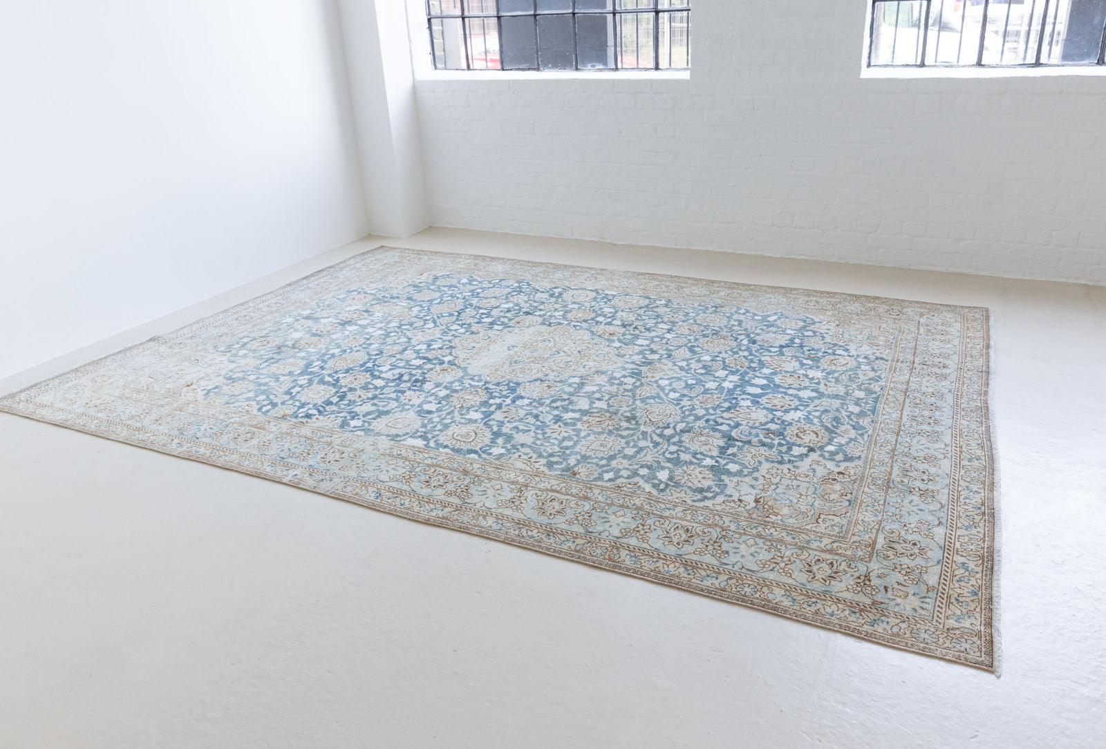 This is a vintage Persian Keshan rug that has been over-dyed to gently fade its original colours, giving a more neutral palette. Persia has the most desirable rugs and carpets with stunning designs such as this carpet. Now available at Ourika London.