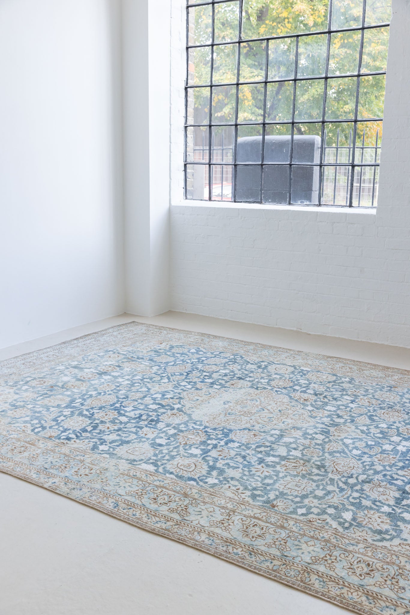 This is a vintage Persian Keshan rug that has been over-dyed to gently fade its original colours, giving a more neutral palette. Persia has the most desirable rugs and carpets with stunning designs such as this carpet. Now available at Ourika London.