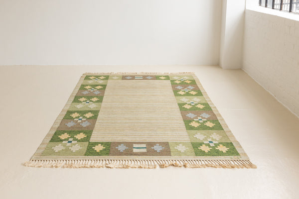Singe is a handwoven Swedish mid century flatweave rug. This vintage rug features beautiful green and brown colour gradients and a pretty geometric border