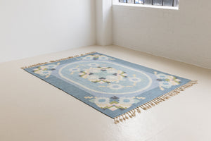 Ingo is a vintage rug handwoven in Sweden by textile designer Ingegerd Silow. Featuring a floral geometric pattern in blues. greens. pinks and black.