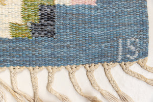 Ingo is a vintage rug handwoven in Sweden by textile designer Ingegerd Silow. Featuring a floral geometric pattern in blues. greens. pinks and black.
