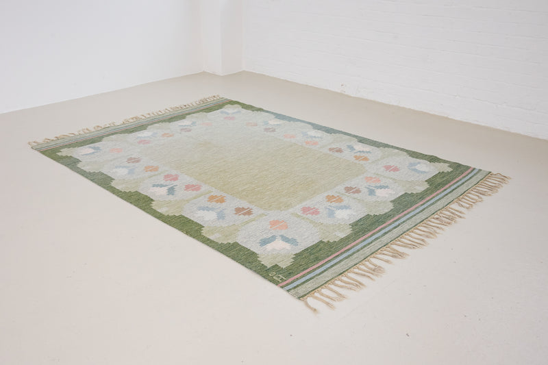 Trudie is an original Swedish röllakan rug handwoven by mid-century textile designer Anna Johanna Angström. Green colour-way featuring floral motifs 