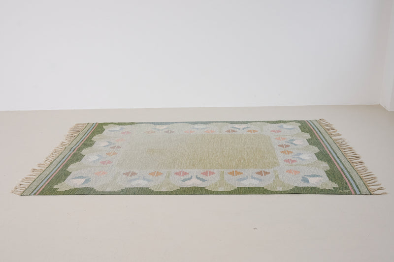 Trudie is an original Swedish röllakan rug handwoven by mid-century textile designer Anna Johanna Angström. Green colour-way featuring floral motifs 