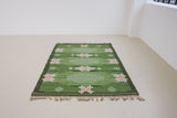 a vintage rug handwoven in Sweden by  textile designer Ingegerd Silow. Green in colour featuring a rare geometric floral motif