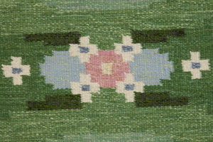 a vintage rug handwoven in Sweden by  textile designer Ingegerd Silow. Green in colour featuring a rare geometric floral motif
