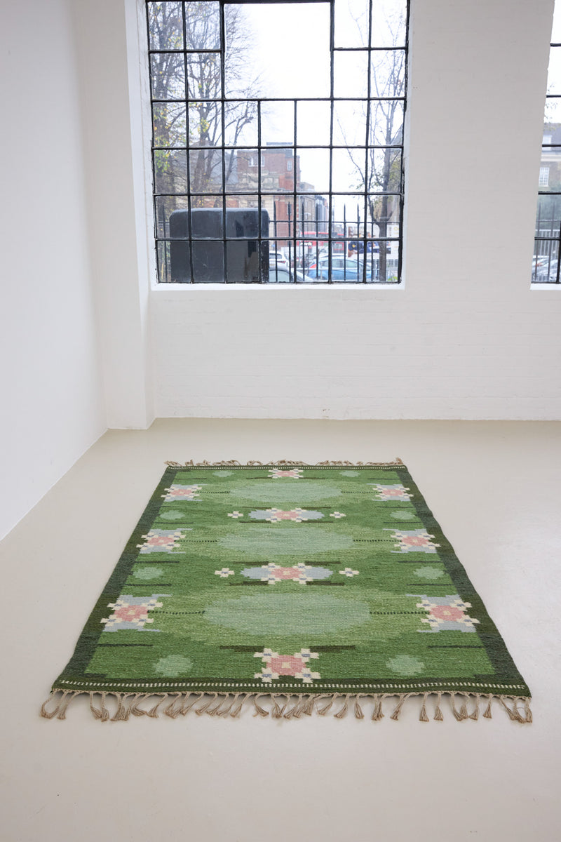 a vintage rug handwoven in Sweden by  textile designer Ingegerd Silow. Green in colour featuring a rare geometric floral motif