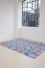 A striking flatweave Swedish rug with geometric pattern featuring blue, purple, and white colours. handwoven in Sweden by textile designer Judith Johanasson.