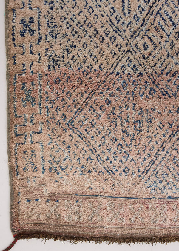 Sylvie is a peach and dark blue geometric patterned vintage Beni Ourain rug with a thick, cozy pile. 