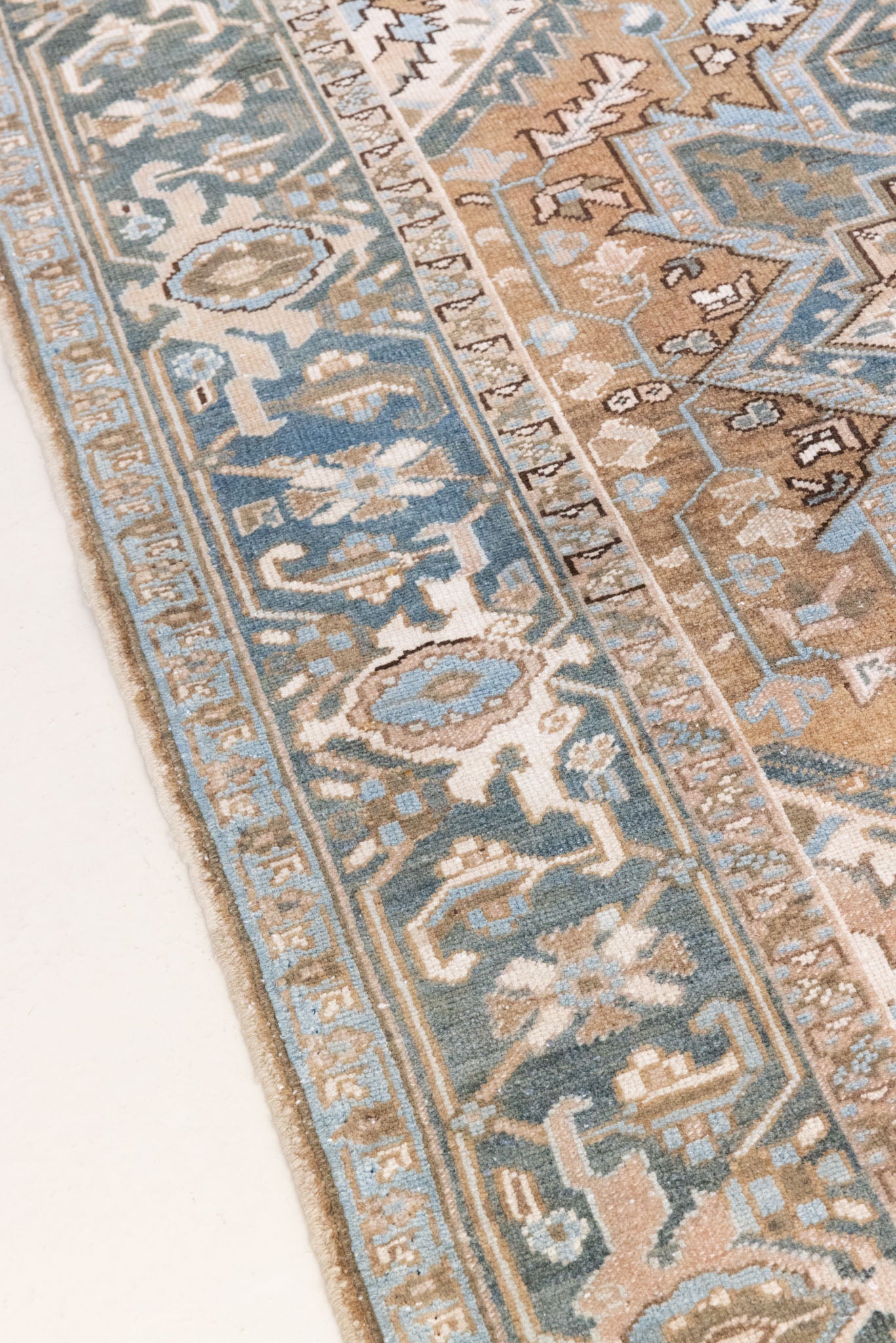 This is a vintage Persian Heriz rug. With a unique antique wash, this carpet boasts a muted palette in soft blue with flashes of red and brown