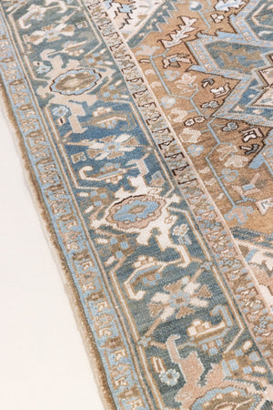This is a vintage Persian Heriz rug. With a unique antique wash, this carpet boasts a muted palette in soft blue with flashes of red and brown