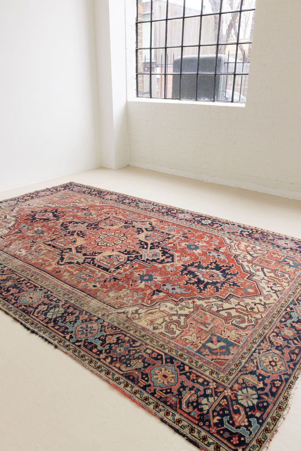 This is a handmade antique Heriz rug woven in Persia. The Heriz region is known for producing some of the most ornate Persian carpet, often known for their mesmerising and intricate repeating patterns.