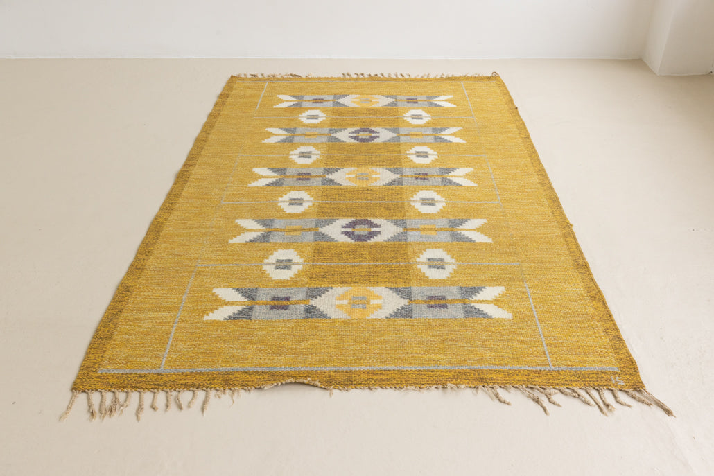 Eliza is a röllakan rug handwoven by textile designer Ingegerd Silow. Featuring a yellow, white and grey pattern