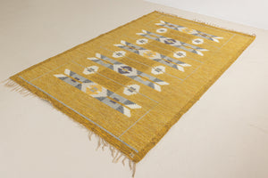 Eliza is a röllakan rug handwoven by textile designer Ingegerd Silow. Featuring a yellow, white and grey pattern