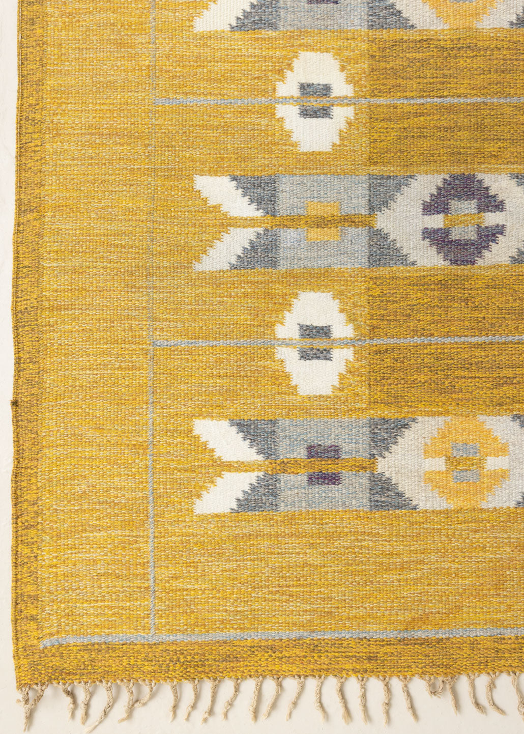 Eliza is a röllakan rug handwoven by textile designer Ingegerd Silow. Featuring a yellow, white and grey pattern