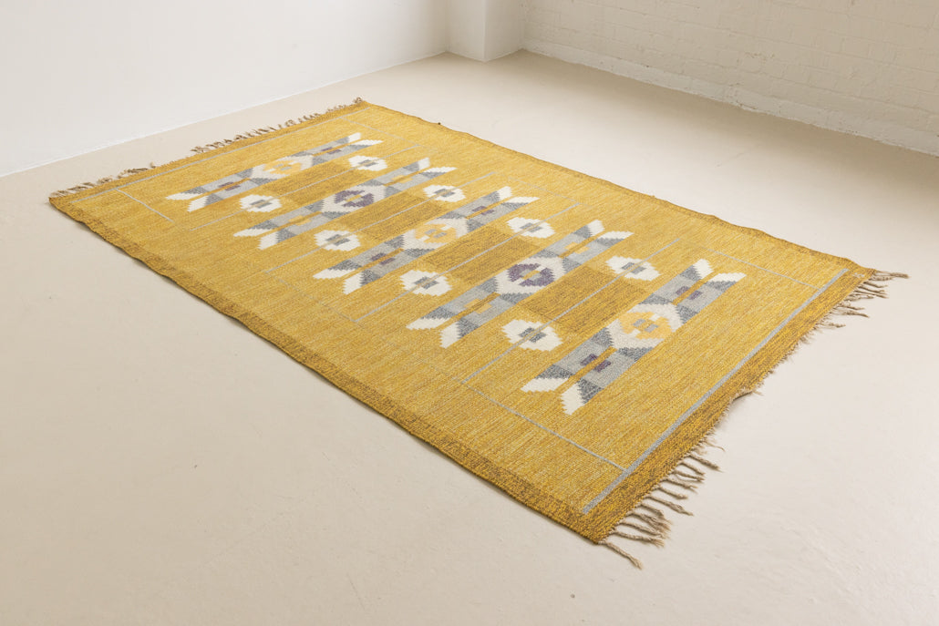 Eliza is a röllakan rug handwoven by textile designer Ingegerd Silow. Featuring a yellow, white and grey pattern