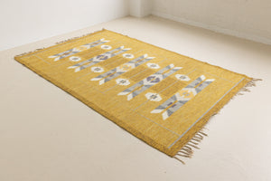 Eliza is a röllakan rug handwoven by textile designer Ingegerd Silow. Featuring a yellow, white and grey pattern