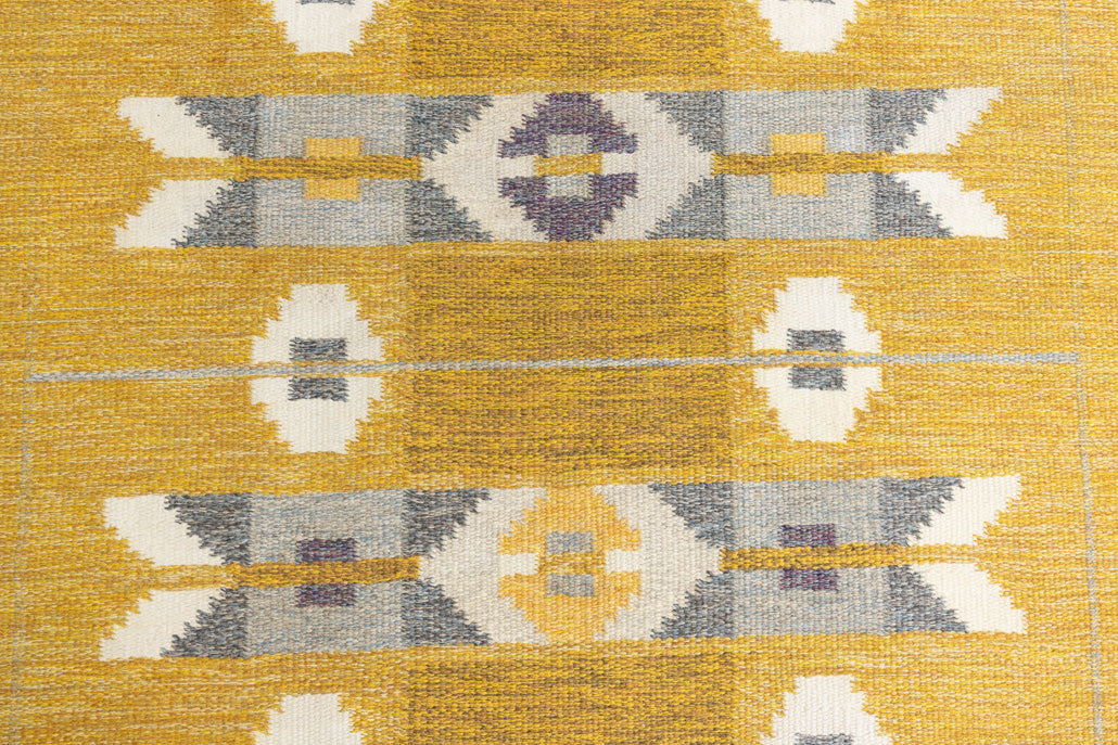Eliza is a röllakan rug handwoven by textile designer Ingegerd Silow. Featuring a yellow, white and grey pattern